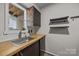 Bright kitchenette with butcher block countertops, stainless steel sink, and open shelving at 415 W 7Th St # H, Charlotte, NC 28202