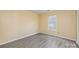 Clean bedroom with sleek floors, light yellow walls, and a bright window providing natural light at 4521 Palustris Ct, Charlotte, NC 28269