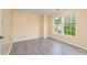 Well-lit bedroom featuring modern gray vinyl floors, light yellow walls, and two bright windows at 4521 Palustris Ct, Charlotte, NC 28269