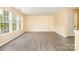 Bright living room featuring wood-look flooring and natural lighting from large windows at 4521 Palustris Ct, Charlotte, NC 28269