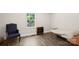 Small bright bedroom with a large window and hardwood floors, featuring a blue chair and small twin bed at 485 Lincoln St, Cramerton, NC 28032