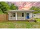 Charming home with a covered porch and blue front door nestled among mature trees at sunset at 485 Lincoln St, Cramerton, NC 28032