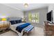 Bedroom boasts natural light, a plush bed with blue accents, and elegant window shutters at 6211 Cruden Bay Way, Charlotte, NC 28277