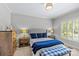 Bright bedroom showcasing a tufted headboard, blue accents, and natural light from the shuttered window at 6211 Cruden Bay Way, Charlotte, NC 28277