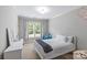 Bright bedroom featuring a white bed and dresser next to a window with blue curtains at 6211 Cruden Bay Way, Charlotte, NC 28277