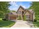 Elegant brick home featuring a spacious three-car garage and lush, green landscaping, with manicured lawn at 6211 Cruden Bay Way, Charlotte, NC 28277