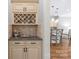 Kitchen butler's pantry area with a wine rack, granite countertop, and cream-colored cabinetry at 6211 Cruden Bay Way, Charlotte, NC 28277