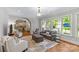 Bright living room featuring hardwood floors, neutral décor, and a seamless transition to the kitchen area at 6211 Cruden Bay Way, Charlotte, NC 28277
