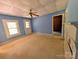 Carpeted bedroom features neutral walls, a ceiling fan, and a doorway to another room at 647 Mckay Hill Rd, Mount Gilead, NC 27306