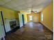 Large bedroom with hardwood floors, bright yellow walls, and classic fireplace, great natural light at 647 Mckay Hill Rd, Mount Gilead, NC 27306