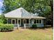 Charming single-story home featuring a covered front porch, light blue siding, and surrounded by mature trees at 647 Mckay Hill Rd, Mount Gilead, NC 27306