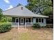 Inviting single-story home boasts light blue siding, white trim, covered front porch, and lush green landscaping at 647 Mckay Hill Rd, Mount Gilead, NC 27306