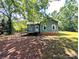 View of exterior featuring wood deck and exterior shade from mature trees at 647 Mckay Hill Rd, Mount Gilead, NC 27306