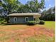 Side view of home with a metal roof and green grass surrounding the perimeter at 647 Mckay Hill Rd, Mount Gilead, NC 27306