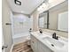 Bathroom featuring double sink vanity with modern fixtures, tub, and tiled shower surround at 6756 Denver Heights Cir, Denver, NC 28037