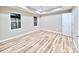 Bedroom with modern wood flooring, tray ceiling, and large windows providing ample light at 6756 Denver Heights Cir, Denver, NC 28037