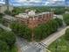 Aerial view of a brick apartment complex surrounded by lush trees, located near the city center at 715 N Church St, Charlotte, NC 28202