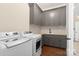 Well-equipped laundry room with gray cabinets, counter space, sink, washer, and dryer at 722 Clegg Farm Dr, York, SC 29745