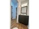 Charming powder room featuring a gray vanity with a marble countertop and wood-look flooring at 8701 W Dixie Dr, Charlotte, NC 28278