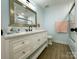 Bathroom with a white vanity, decorative mirror, and a shower at 8701 W Dixie Dr, Charlotte, NC 28278