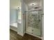 Stylish bathroom featuring a bathtub, walk-in shower with unique tile and glass door at 8701 W Dixie Dr, Charlotte, NC 28278