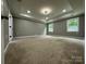 Large carpeted bedroom with a tray ceiling, recessed lights, and bright windows at 8701 W Dixie Dr, Charlotte, NC 28278