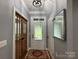 Inviting foyer with hardwood floors, decorative rug, glass front door, and neutral color palette at 8701 W Dixie Dr, Charlotte, NC 28278