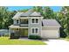 Charming two-story home with a well-manicured lawn, beautiful plants, gray siding, and a welcoming yellow front door at 8701 W Dixie Dr, Charlotte, NC 28278