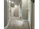 Neutral-toned hallway with multiple white doors, neutral walls, and neutral carpeting at 8701 W Dixie Dr, Charlotte, NC 28278