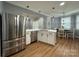 Open-concept kitchen with island, stainless steel appliances, and breakfast nook dining area at 8701 W Dixie Dr, Charlotte, NC 28278