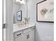 Stylish half bathroom featuring white vanity with modern fixtures, decorative mirror, and elegant artwork at Lot 003 Bozeman Ct # 3, Stanley, NC 28164
