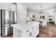 Open kitchen with stainless steel refrigerator and island flowing into dining and living areas at Lot 003 Bozeman Ct # 3, Stanley, NC 28164