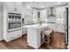 Modern kitchen with white cabinetry, stainless steel appliances, a center island with seating and sleek fixtures, and hardwood floors at Lot 003 Bozeman Ct # 3, Stanley, NC 28164