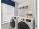 Well-lit laundry room equipped with modern washer and dryer, and convenient storage shelves for supplies at Lot 003 Bozeman Ct # 3, Stanley, NC 28164