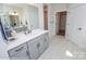 Bathroom with double sink vanity, white countertops, gray cabinetry, and tiled floor with an open doorway at Lot 29 Bozeman Ct # 29, Stanley, NC 28164