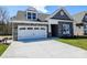 Charming home featuring a stone facade, dormer window, well-manicured lawn, and a two-car garage at Lot 29 Bozeman Ct # 29, Stanley, NC 28164