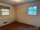 A modest bedroom offers natural light from two windows, with hardwood floors at 112 Greenwood Ave, Belmont, NC 28012