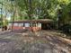 View of home's front exterior with brick accent, covered porch, and mature trees at 112 Greenwood Ave, Belmont, NC 28012
