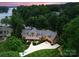 Breathtaking aerial view of lakeside home surrounded by lush greenery with lake access and manicured lawn at 116 Creeky Hollow Dr, Mooresville, NC 28117