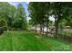 Expansive backyard leads to the lake, featuring a manicured lawn, mature trees, and a picturesque waterfront view at 116 Creeky Hollow Dr, Mooresville, NC 28117