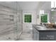 Bathroom featuring an enclosed shower with decorative tile accents, a granite vanity, and natural light at 116 Creeky Hollow Dr, Mooresville, NC 28117