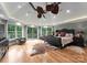 Luxurious bedroom boasts a tray ceiling, a fan, hardwood floors, and plenty of natural light and outdoor views at 116 Creeky Hollow Dr, Mooresville, NC 28117