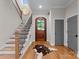 Inviting foyer with hardwood floors, a staircase, and a decorative round mirror at 116 Creeky Hollow Dr, Mooresville, NC 28117