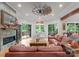 Spacious living room with leather sofas, a fireplace, and large windows overlooking the backyard at 116 Creeky Hollow Dr, Mooresville, NC 28117