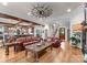 Open-concept living room with hardwood floors, exposed beams, and a connecting kitchen and staircase at 116 Creeky Hollow Dr, Mooresville, NC 28117