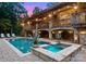 Luxury pool area with an attached spa, stone accents, multi-level balconies, and a twilight sky at 116 Creeky Hollow Dr, Mooresville, NC 28117