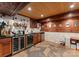 A wet bar featuring wooden cabinetry, granite countertops, wine coolers, and decorative accents at 116 Creeky Hollow Dr, Mooresville, NC 28117