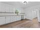 Well-lit kitchen with white cabinets, granite countertops, stainless steel dishwasher and hardwood flooring at 118 Cabarrus W Ave, Concord, NC 28025