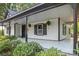 Welcoming front porch with plants, dark accents and a light painted floor and ceiling at 118 Cabarrus W Ave, Concord, NC 28025