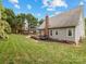 Exterior view of the backyard with lush green lawn, patio, deck, and well-maintained landscaping at 15313 Moate Ct, Huntersville, NC 28078